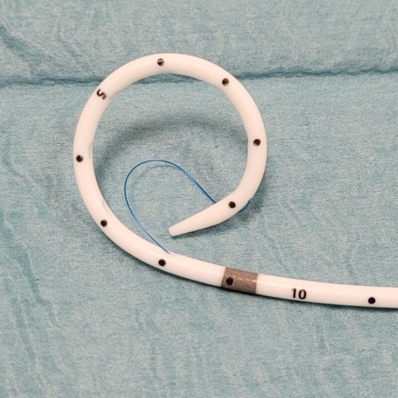 Ces sondes sont bloquées par un fil qui est solidarisé à l’extrémité de la boucle, puis ce fil entre dans la sonde à la base de la boucle en J (visualisée par un repère radio-opaque, qui sert également de repère entre la partie de sonde trouée et le reste de la sonde non trouée) et sort au niveau du luer lock pour être bloqué par un système de verrouillage.