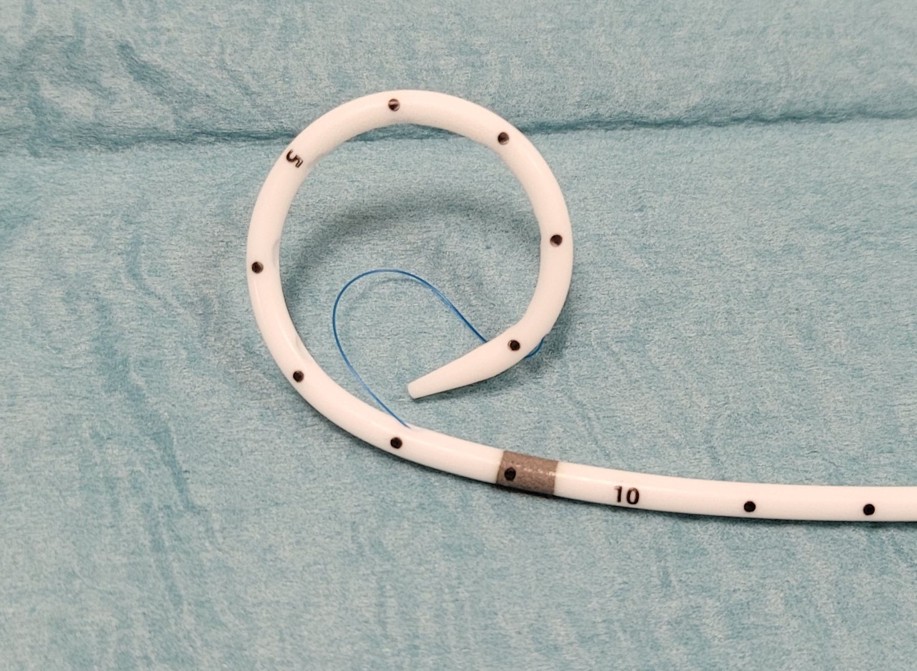 Ces sondes sont bloquées par un fil qui est solidarisé à l’extrémité de la boucle, puis ce fil entre dans la sonde à la base de la boucle en J (visualisée par un repère radio-opaque, qui sert également de repère entre la partie de sonde trouée et le reste de la sonde non trouée) et sort au niveau du luer lock pour être bloqué par un système de verrouillage.