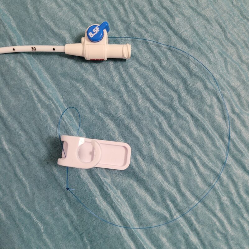 Ces sondes sont bloquées par un fil qui est solidarisé à l’extrémité de la boucle, puis ce fil entre dans la sonde à la base de la boucle en J (visualisée par un repère radio- opaque, qui sert également de repère entre la partie de sonde trouée et le reste de la sonde non trouée) et sort au niveau du luer lock pour être bloquée par un système de verrouillage.