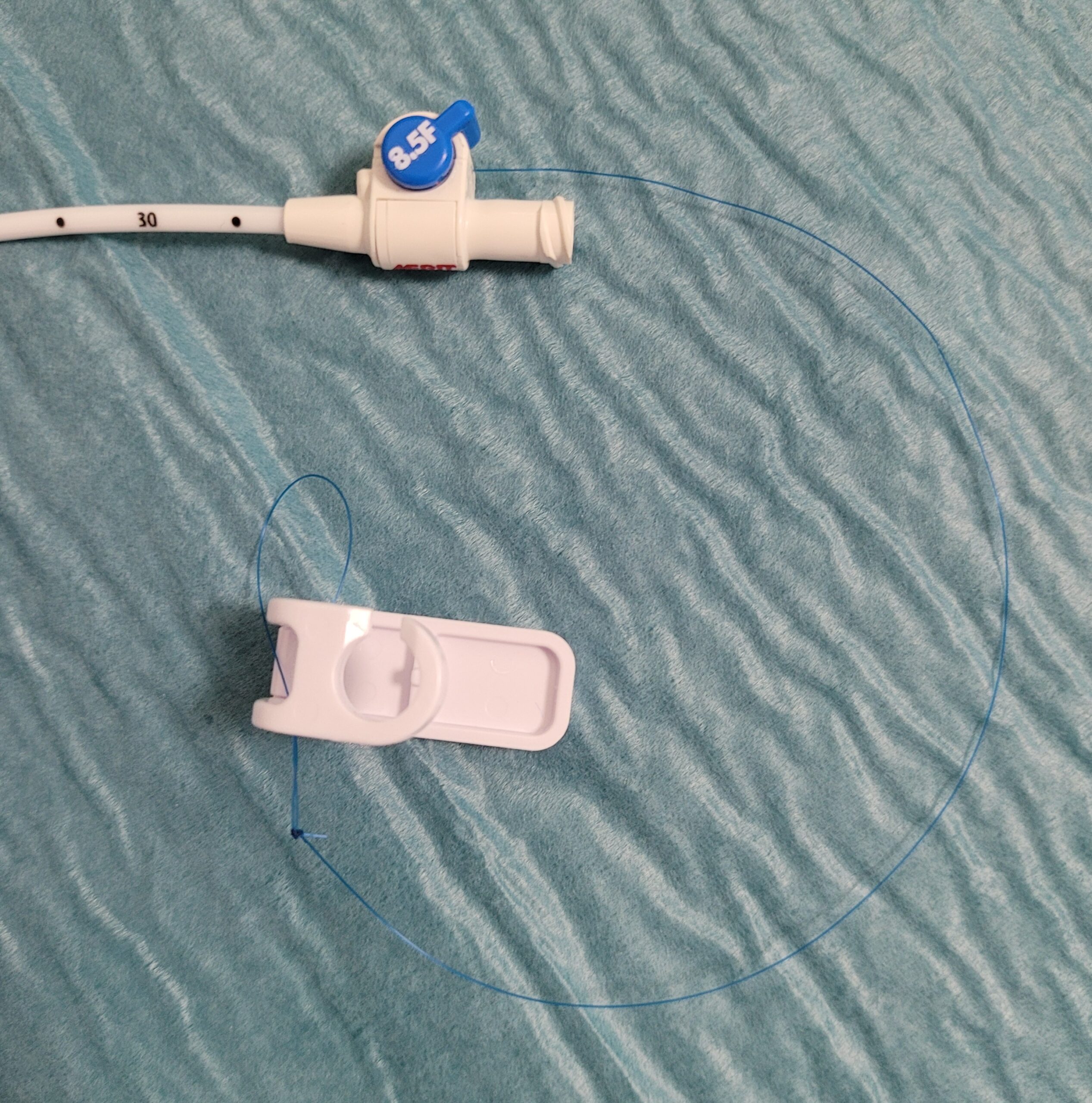 Ces sondes sont bloquées par un fil qui est solidarisé à l’extrémité de la boucle, puis ce fil entre dans la sonde à la base de la boucle en J (visualisée par un repère radio- opaque, qui sert également de repère entre la partie de sonde trouée et le reste de la sonde non trouée) et sort au niveau du luer lock pour être bloquée par un système de verrouillage.